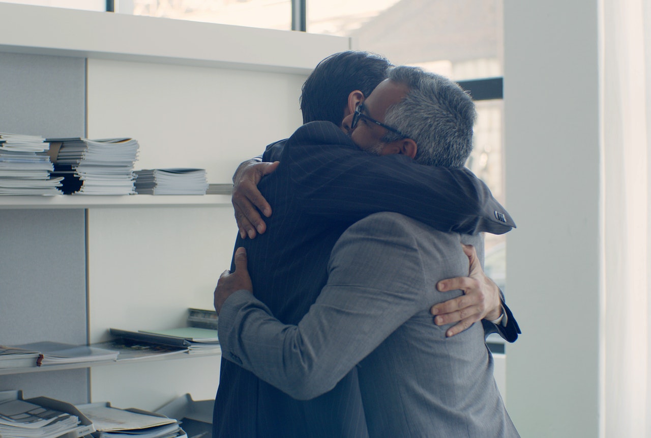 Two-employees-having-a-hug-in-an-office