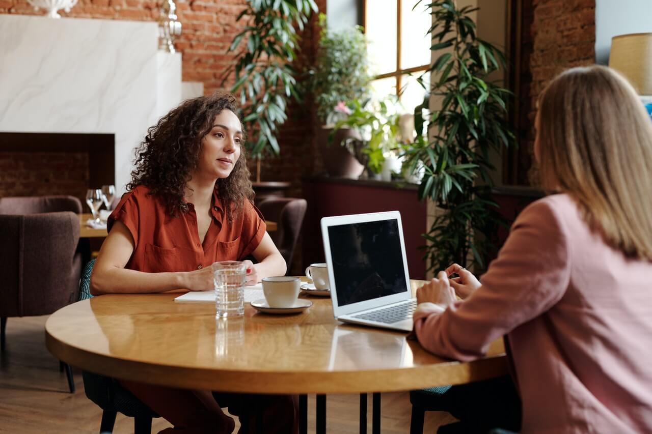 Women sitting on a table conducting an interview