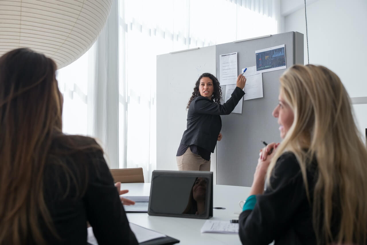 Woman in Corporate Attire Presenting in a Meeting