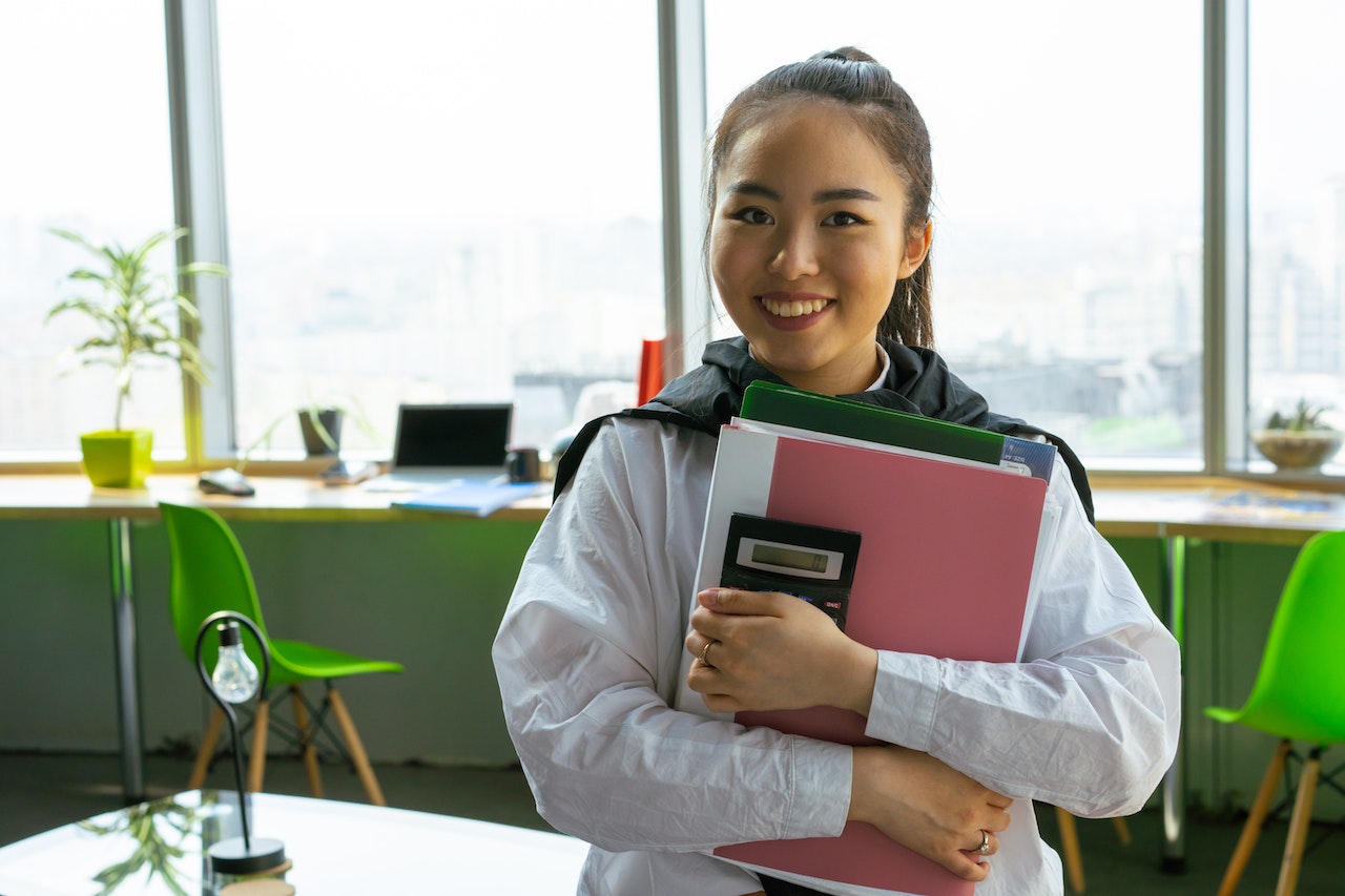 -young-woman-holding-documents-with-calculator-and-smiling