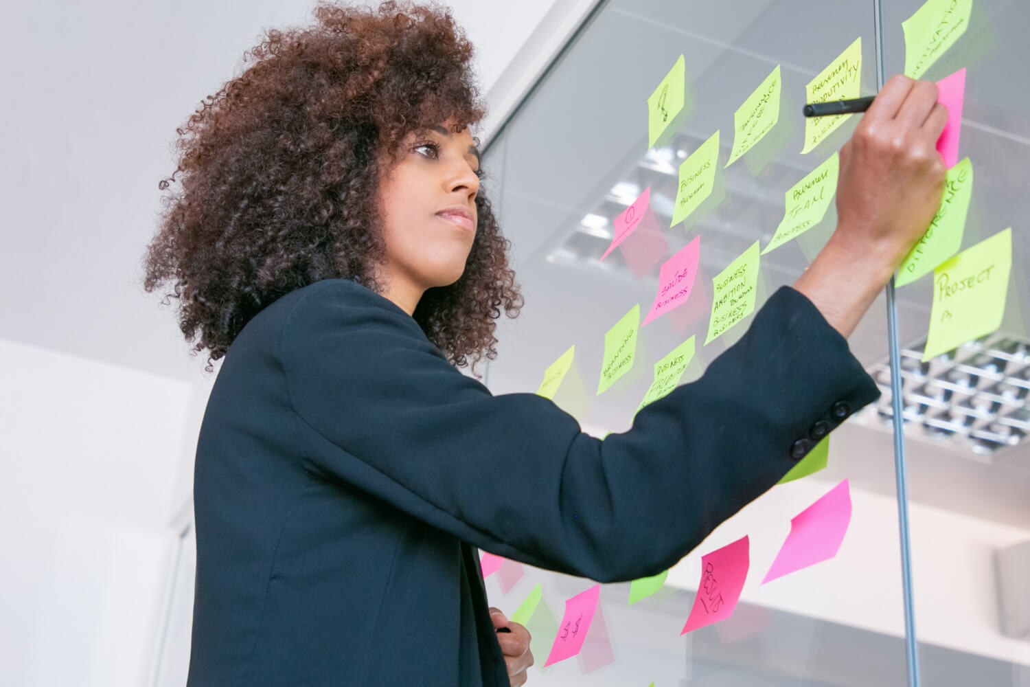 Young lady writing sticker with marker on business training conccept