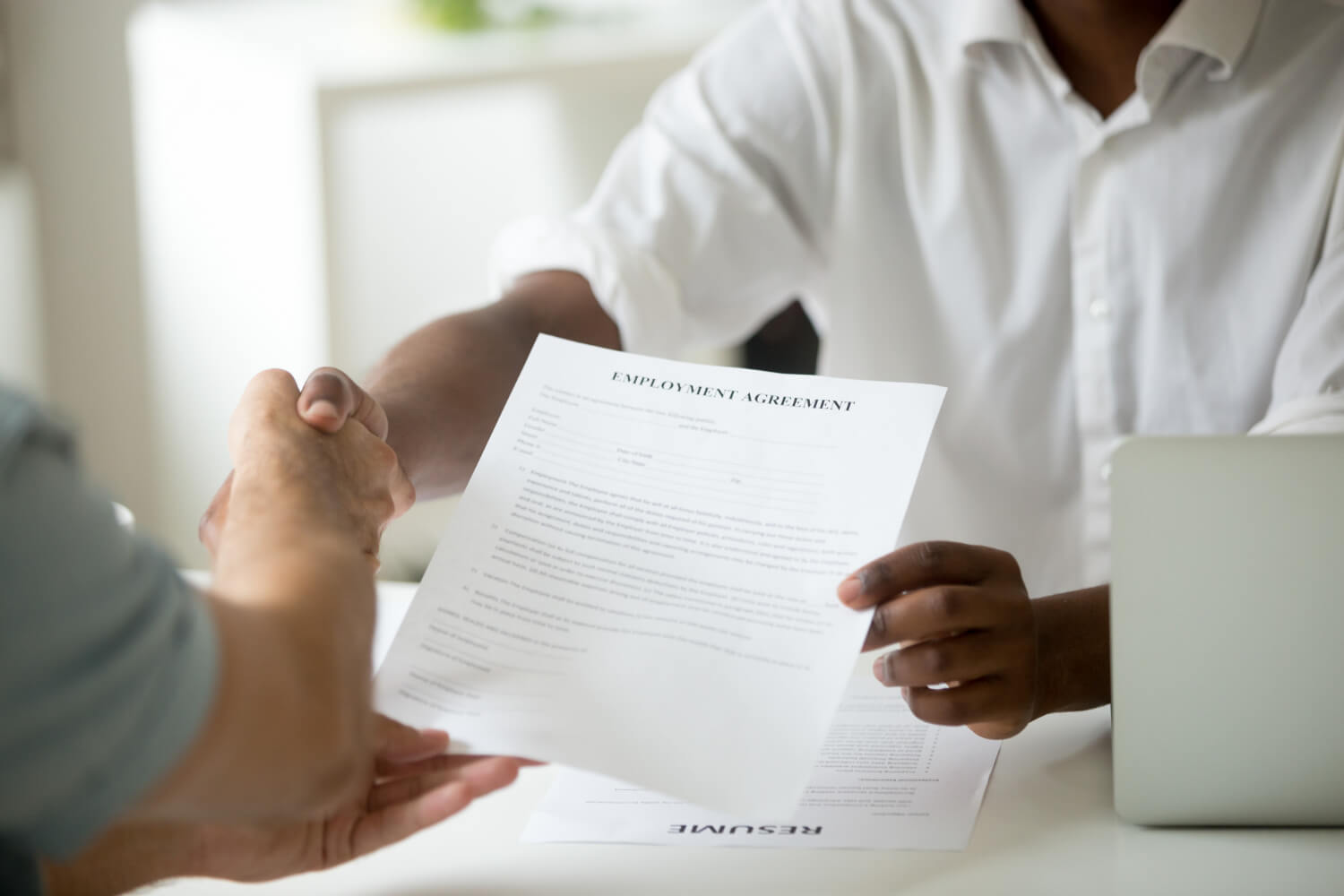 Employee shaking hands with his boss over employment agreement