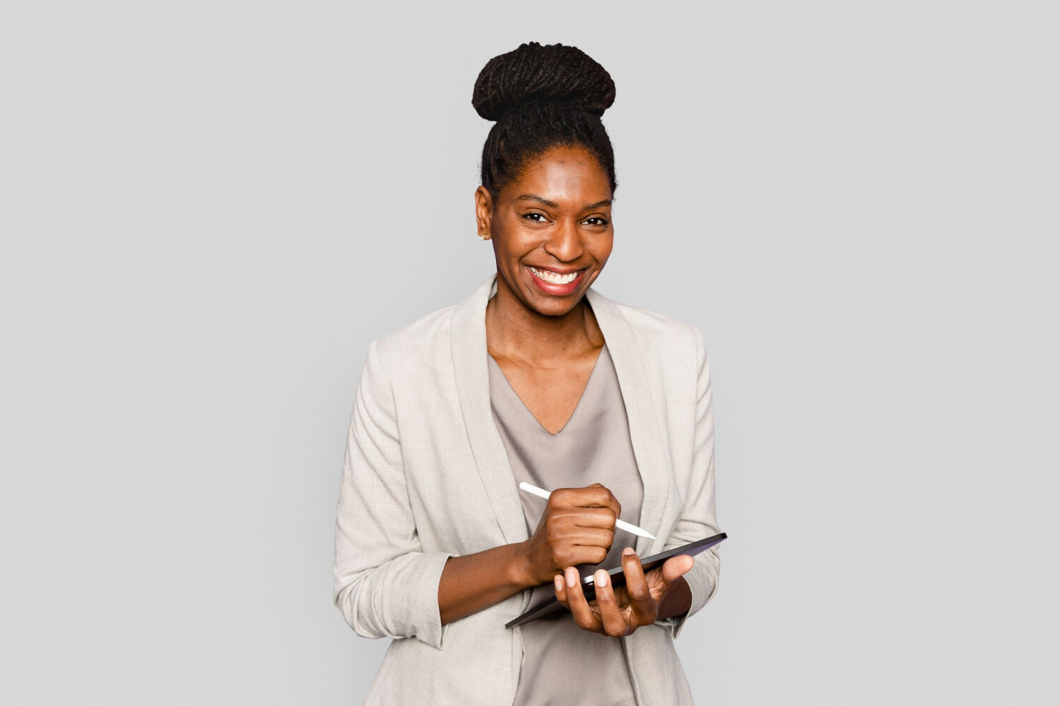 Smiling-woman-writing-notes-tablet-digital-device