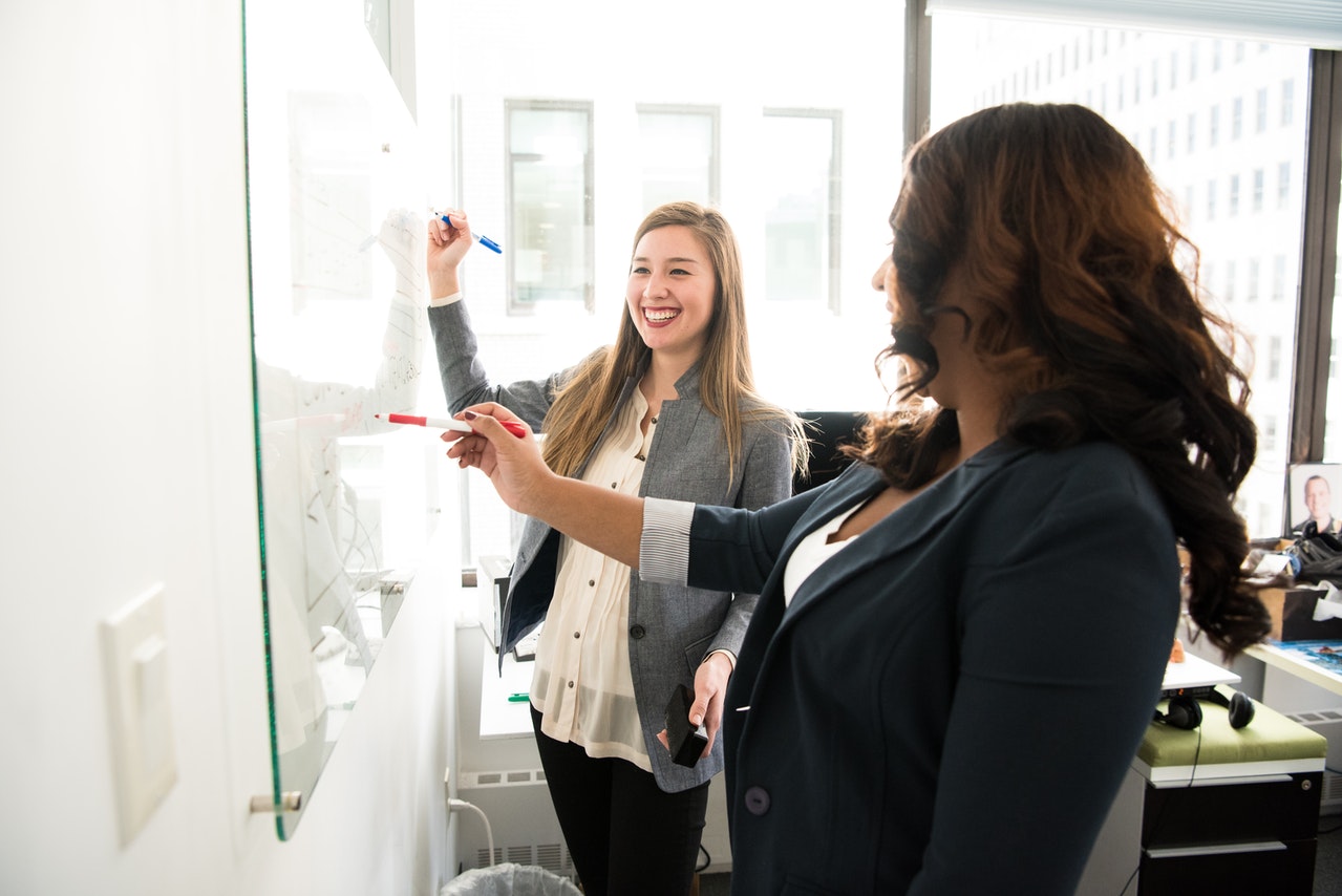 Two Women in Front of A Board