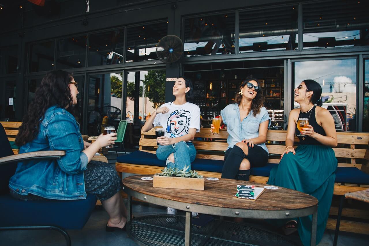 Women Chatting While Sitting on Bench