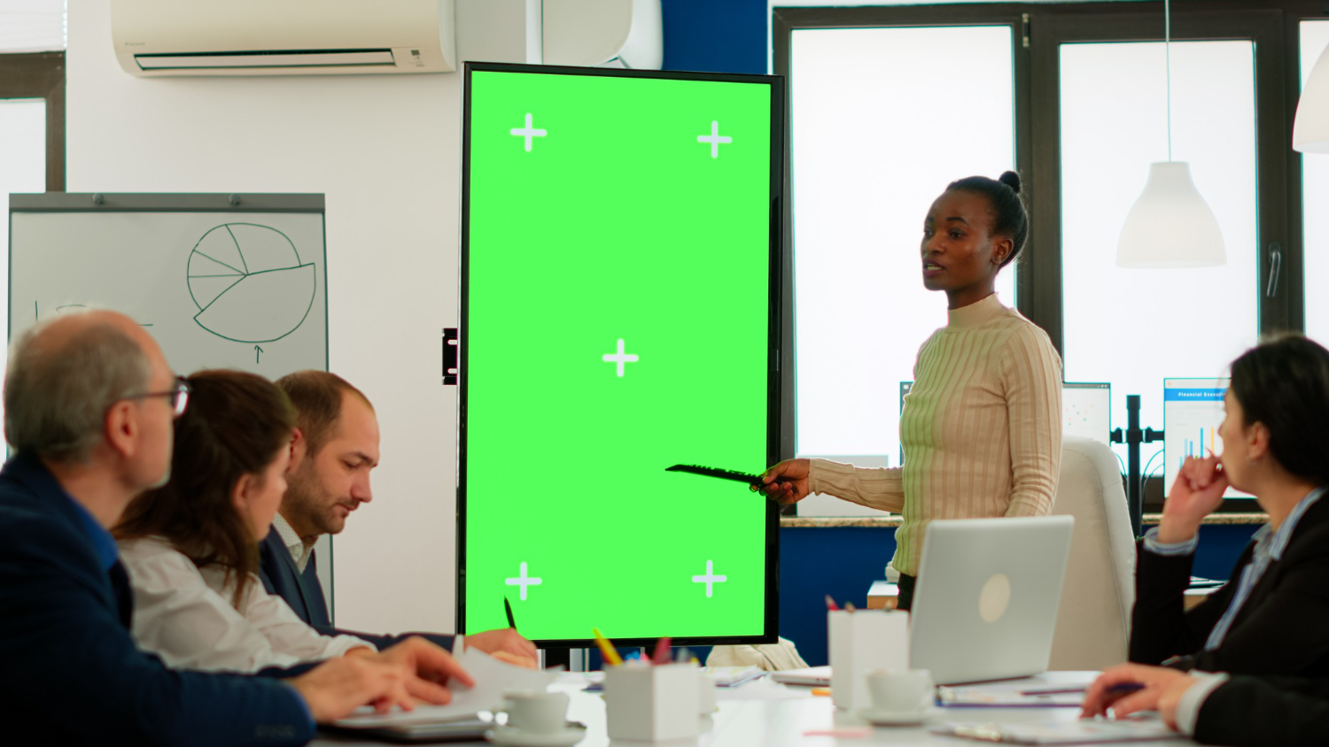 A black woman giving a power polint presentation to colleagues