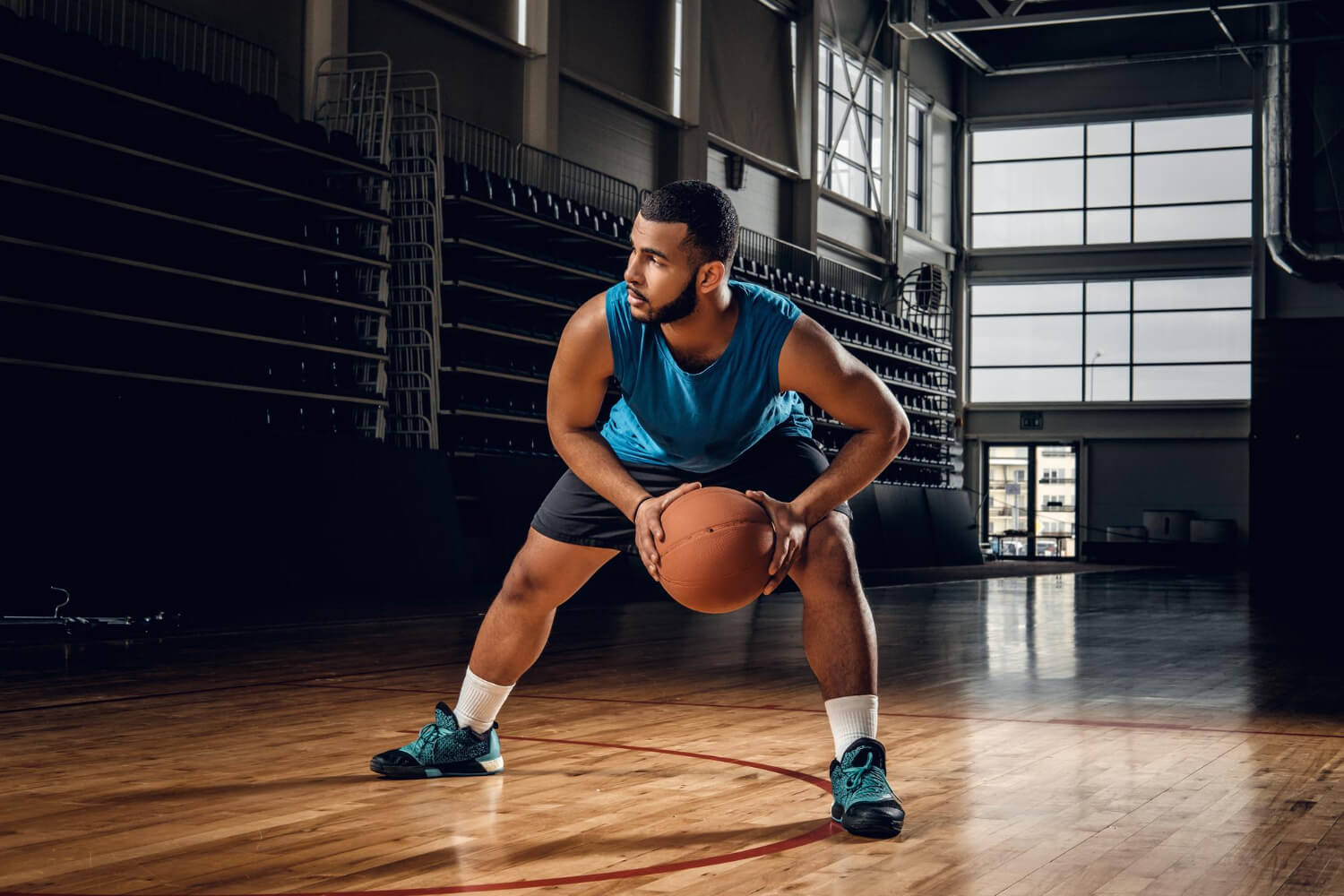 A basketball player practicing in an indoor court