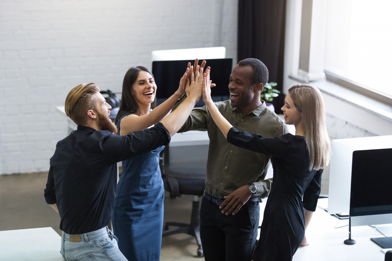 group-young-colleagues-giving-each-other-high-five.