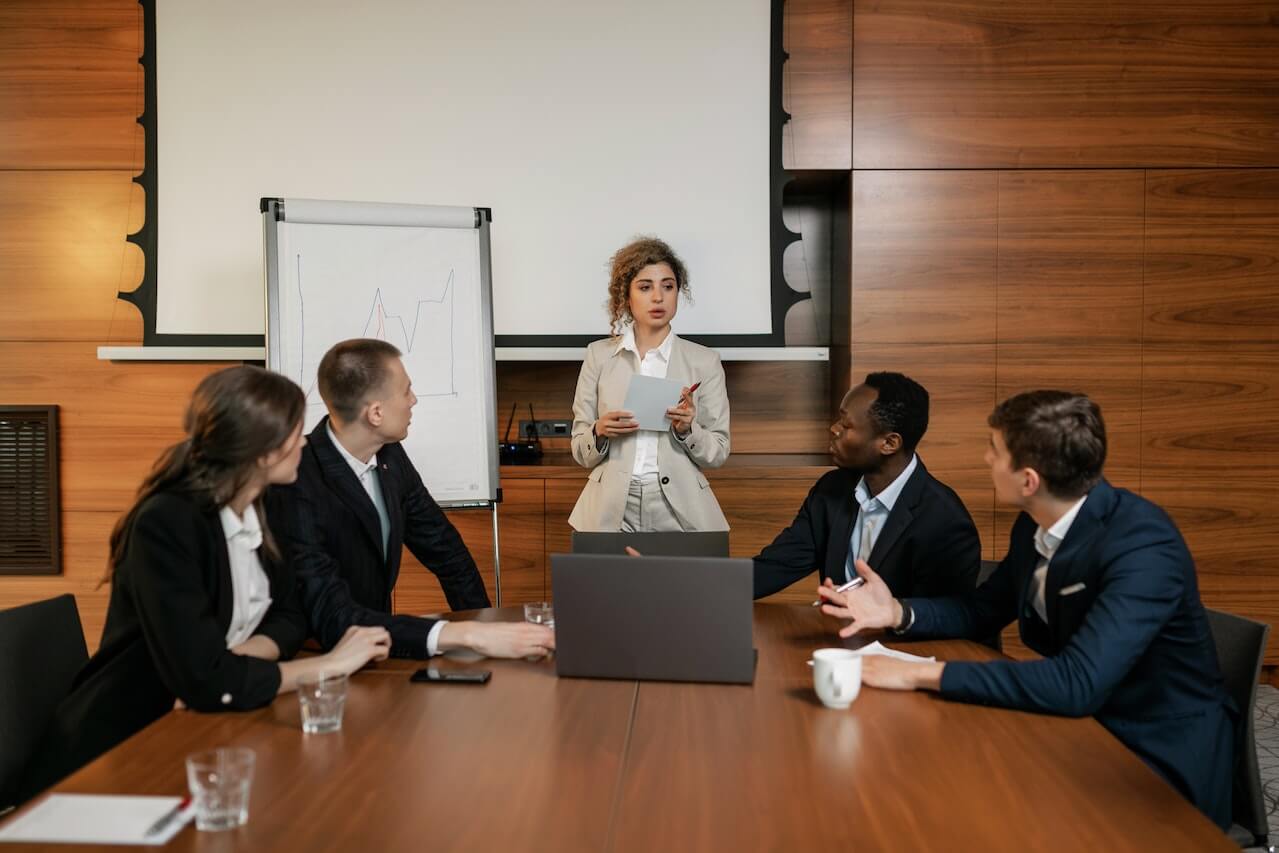 A Woman in Beige Blazer Talking to Her Employees