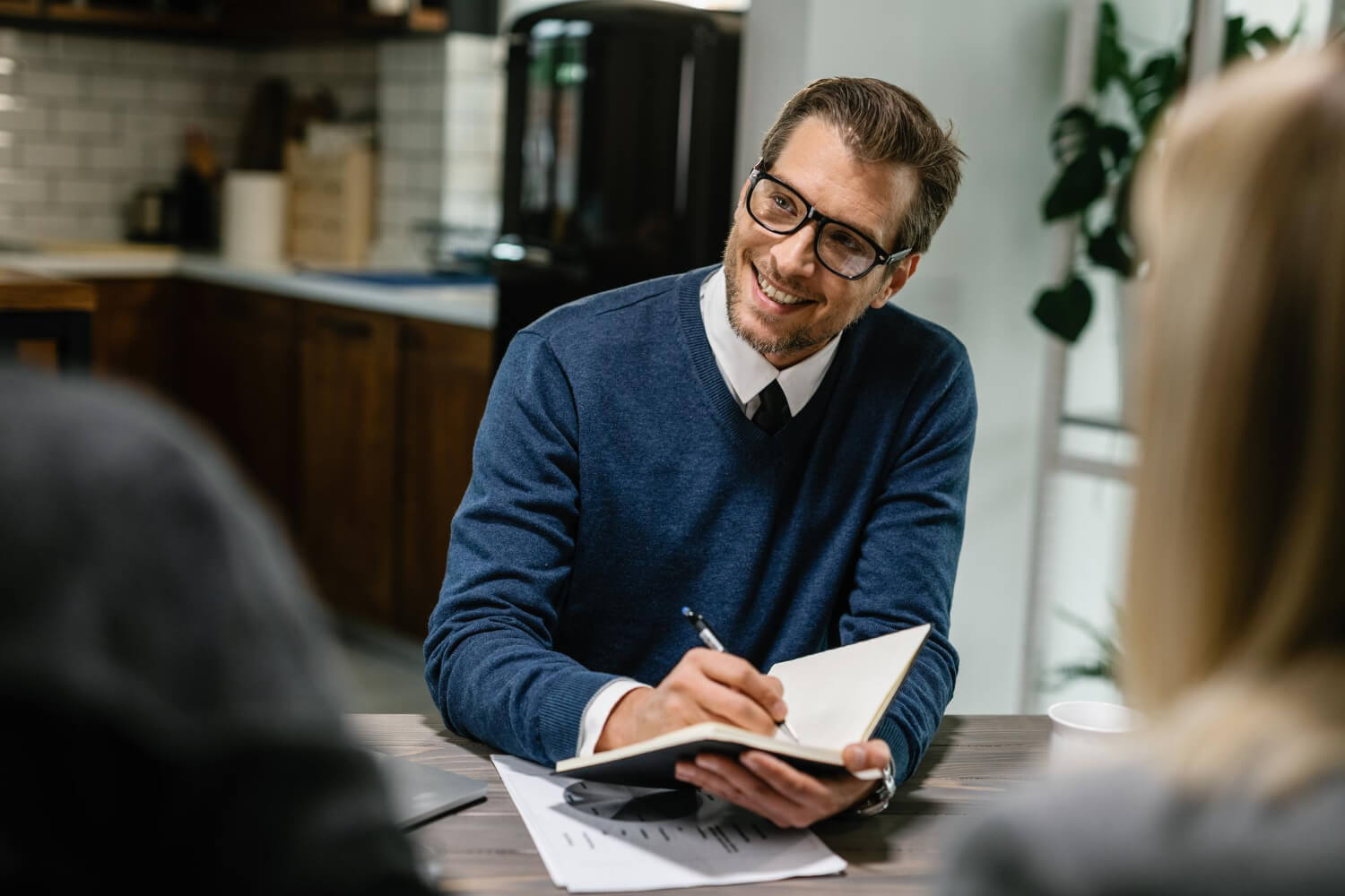 An-employer-taking-notes-while-communicating-with-this-employees-