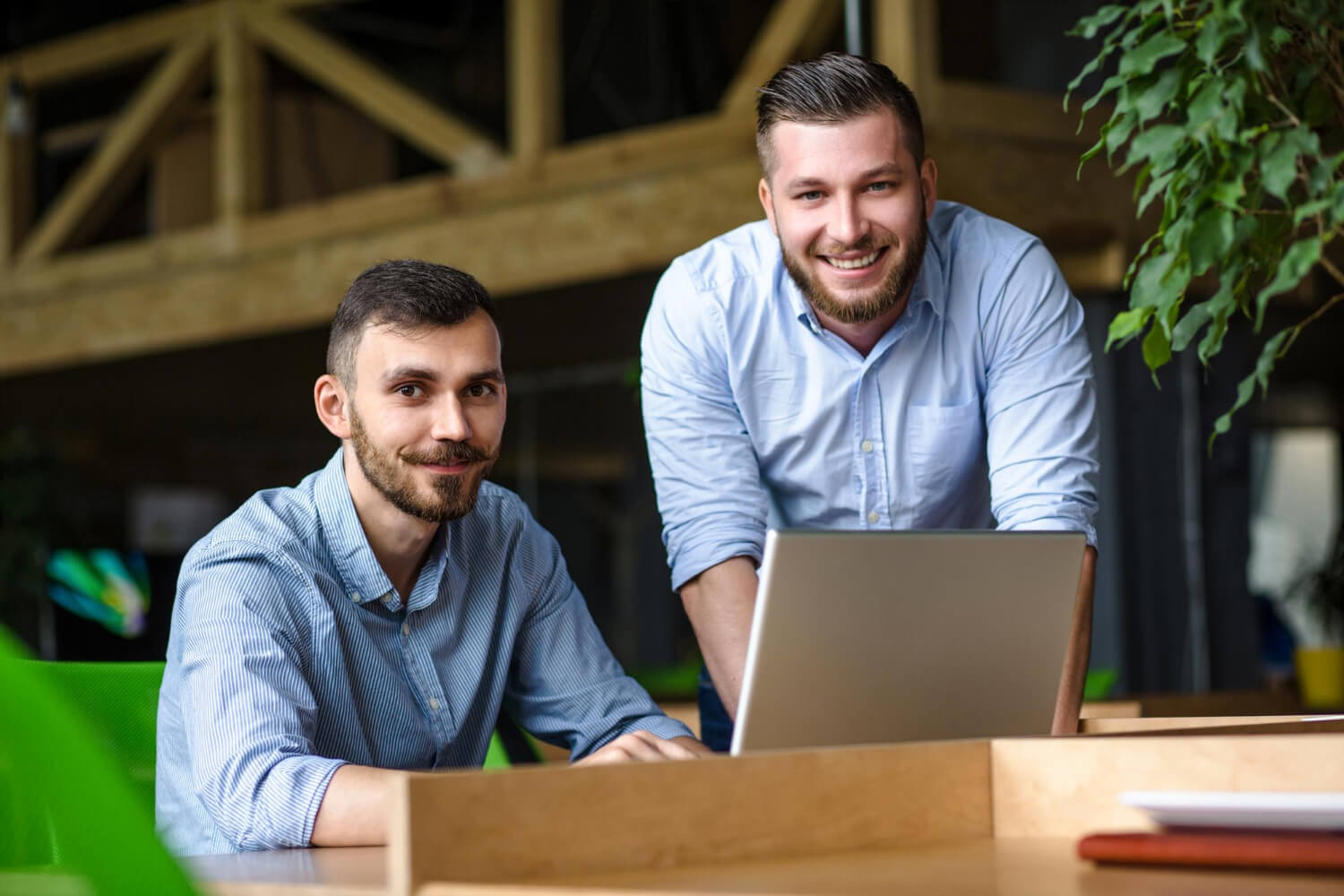 Businessman-listening business partner-while-working on his-laptop