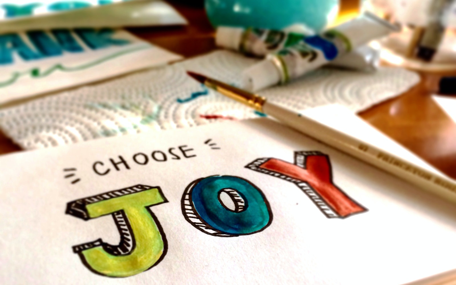 The words "choose joy" written on a paper