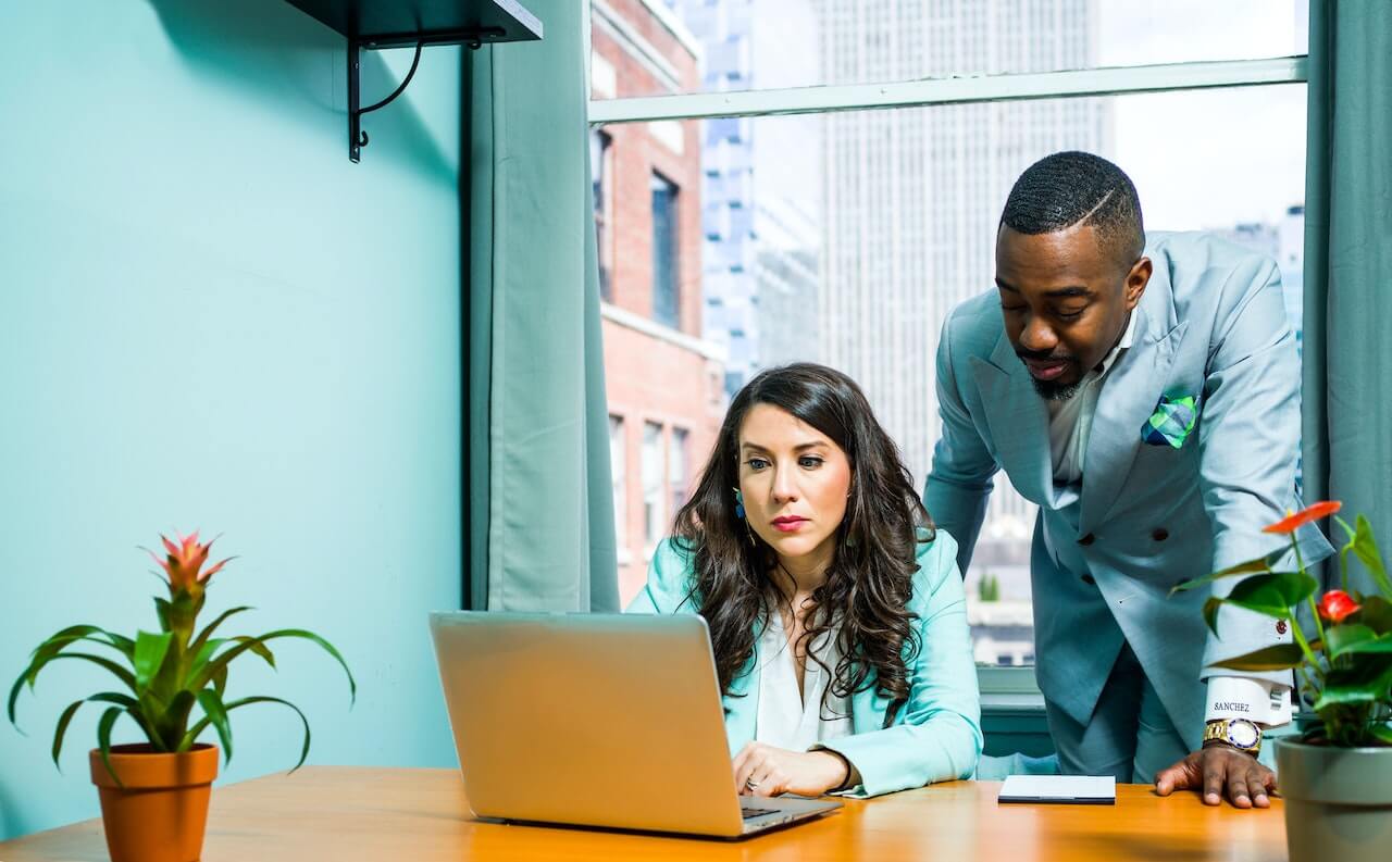 Man on gray suit besides woman assisting her