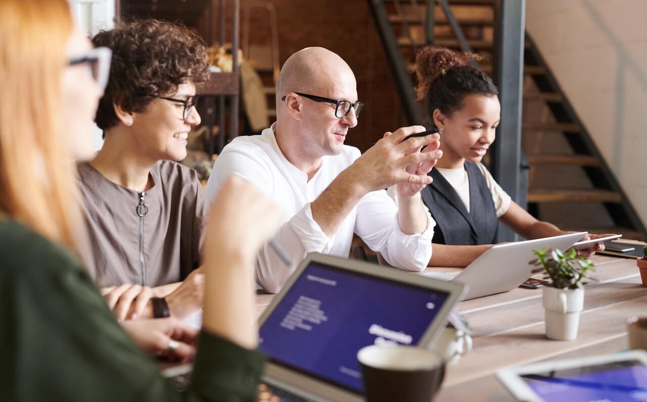 People Looking On Laptop While Discussing