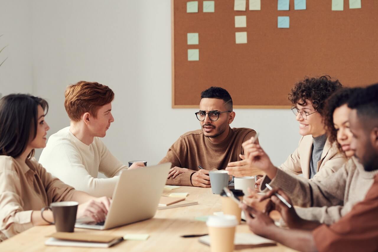 Photo Of People Near Cork Board Having a Meeting