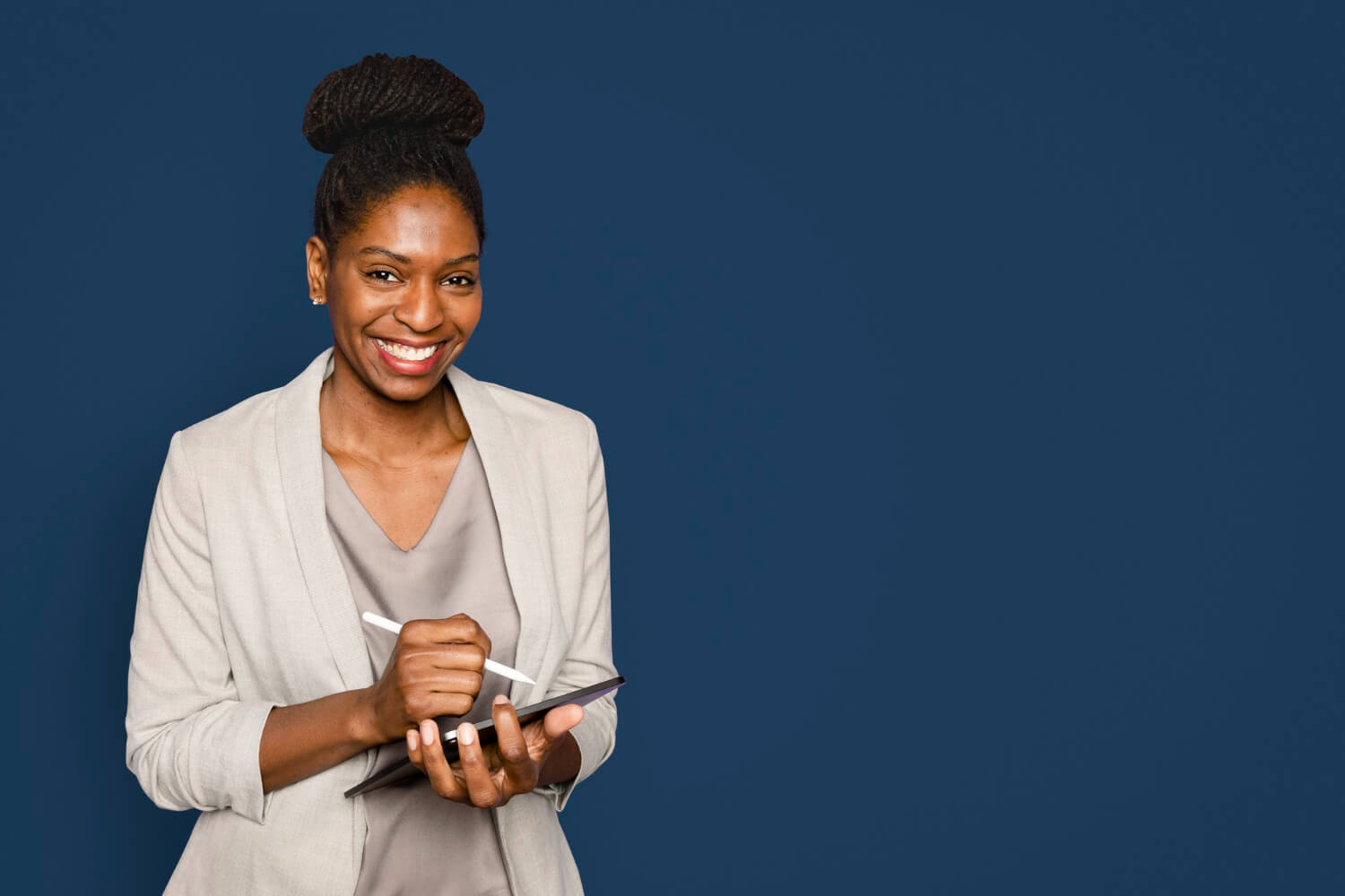 Smiling-woman-writing-notes-tablet-device