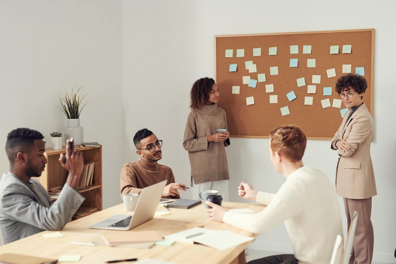 Women standing beside corkboard in a meeting