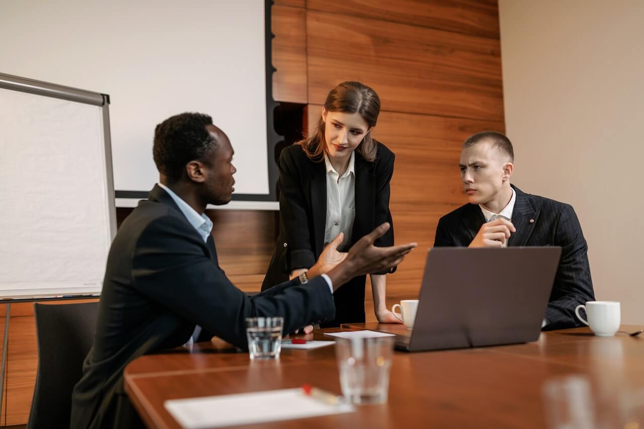 Young lady looking at the man talking while in a meeting