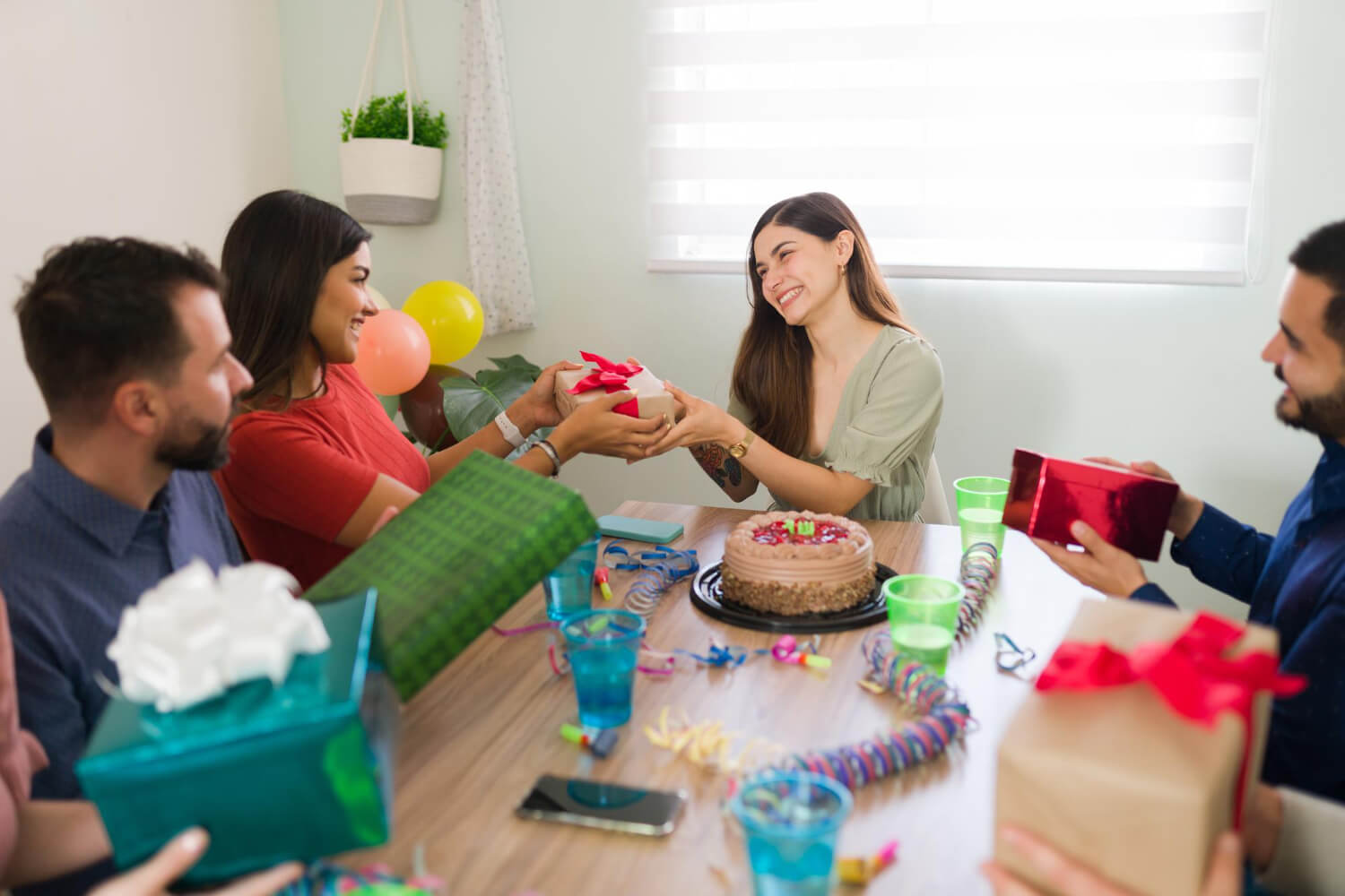 friend-giving-happy-woman-beautiful-birthday-present-during-fun-celebration-home-with-confetti-cake.