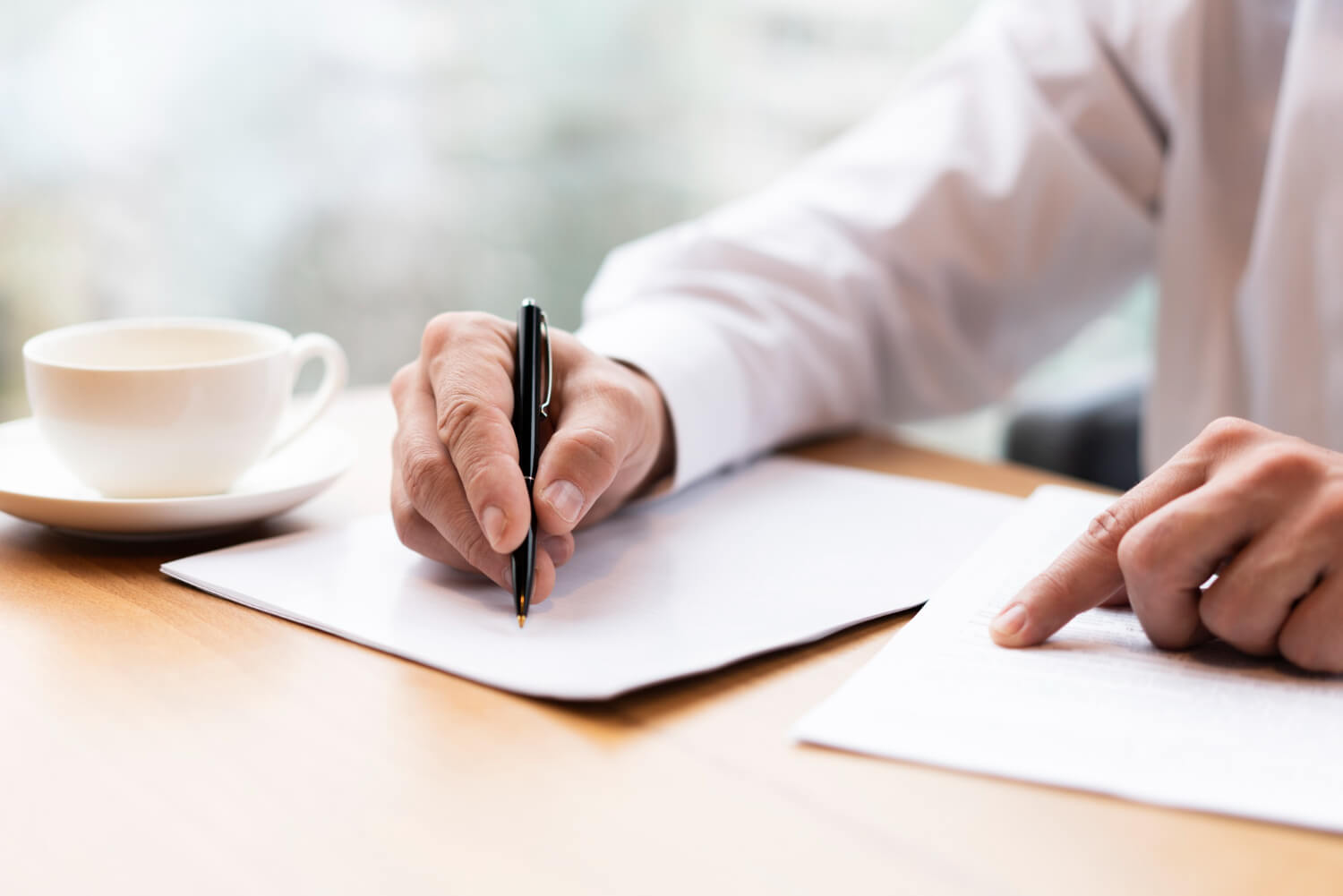 A businessman filling a form for a business checking account on a desk