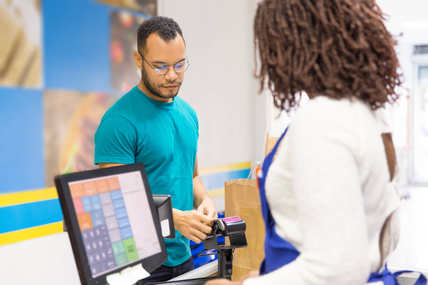 Customer using a pos software to pay at a small business' counter