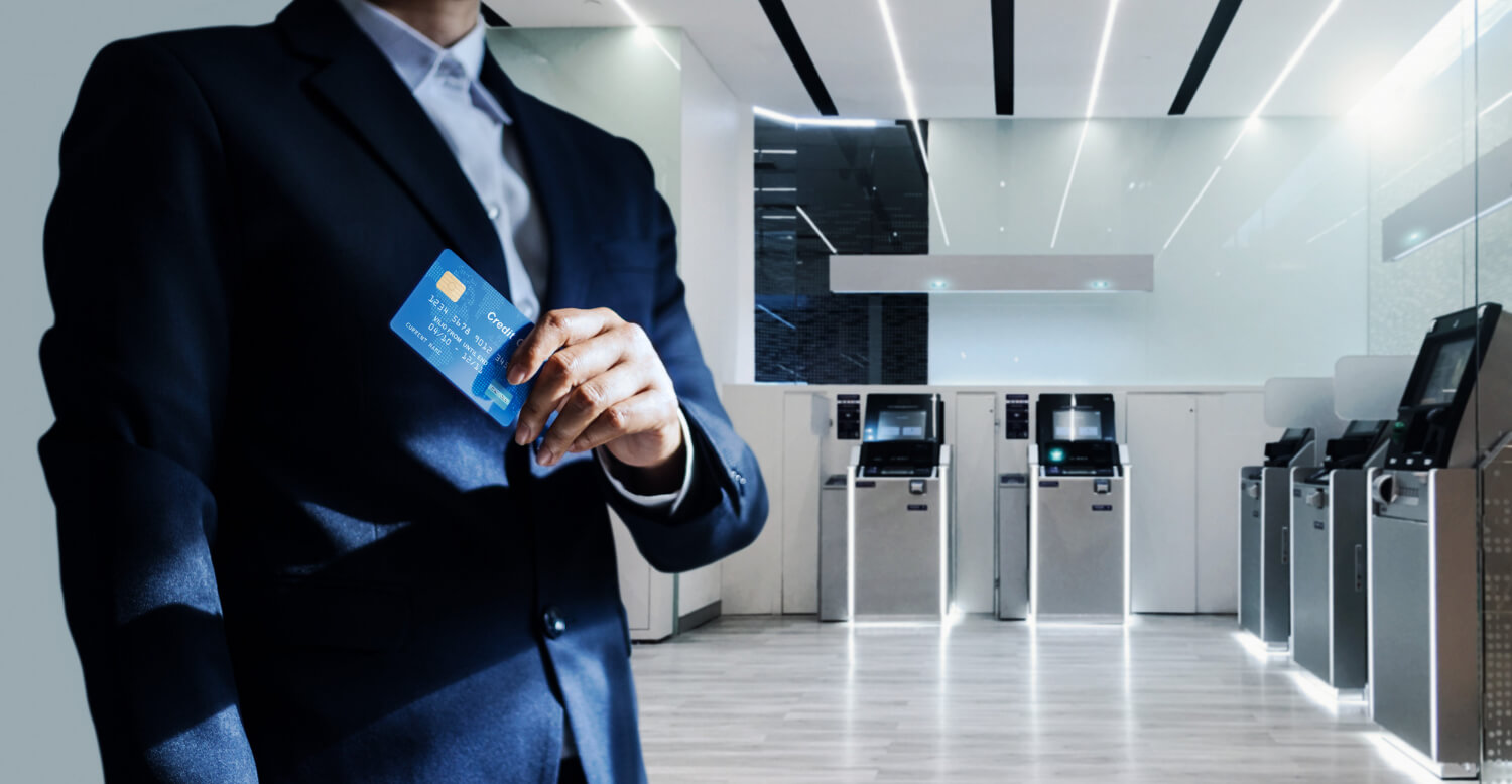 Businessman holding an ATM card in an ATM gallery