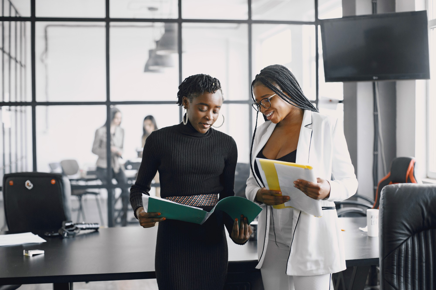 Business women talking near the desk during a coffee break