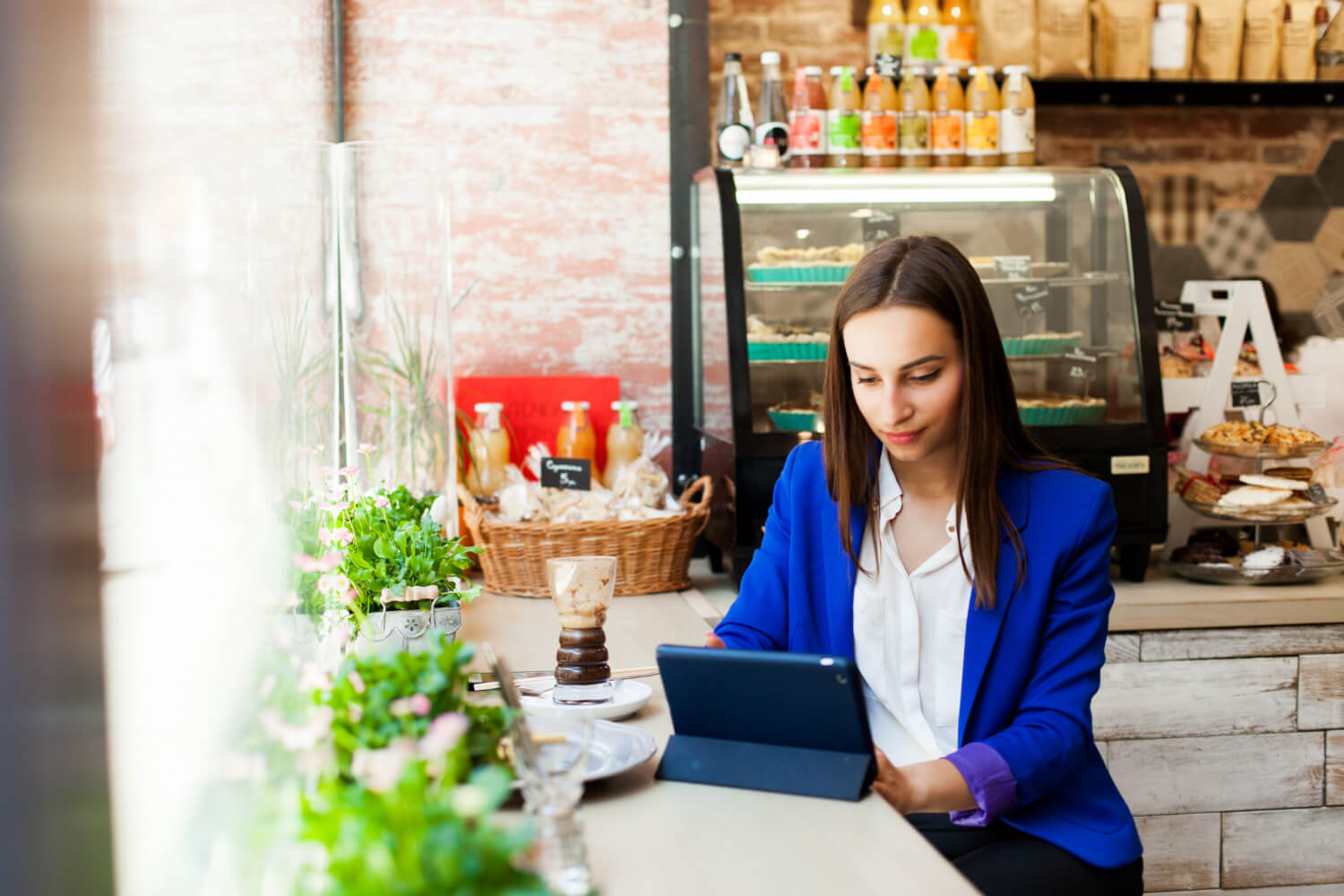 Businesswoman working with her tablet in a cafe