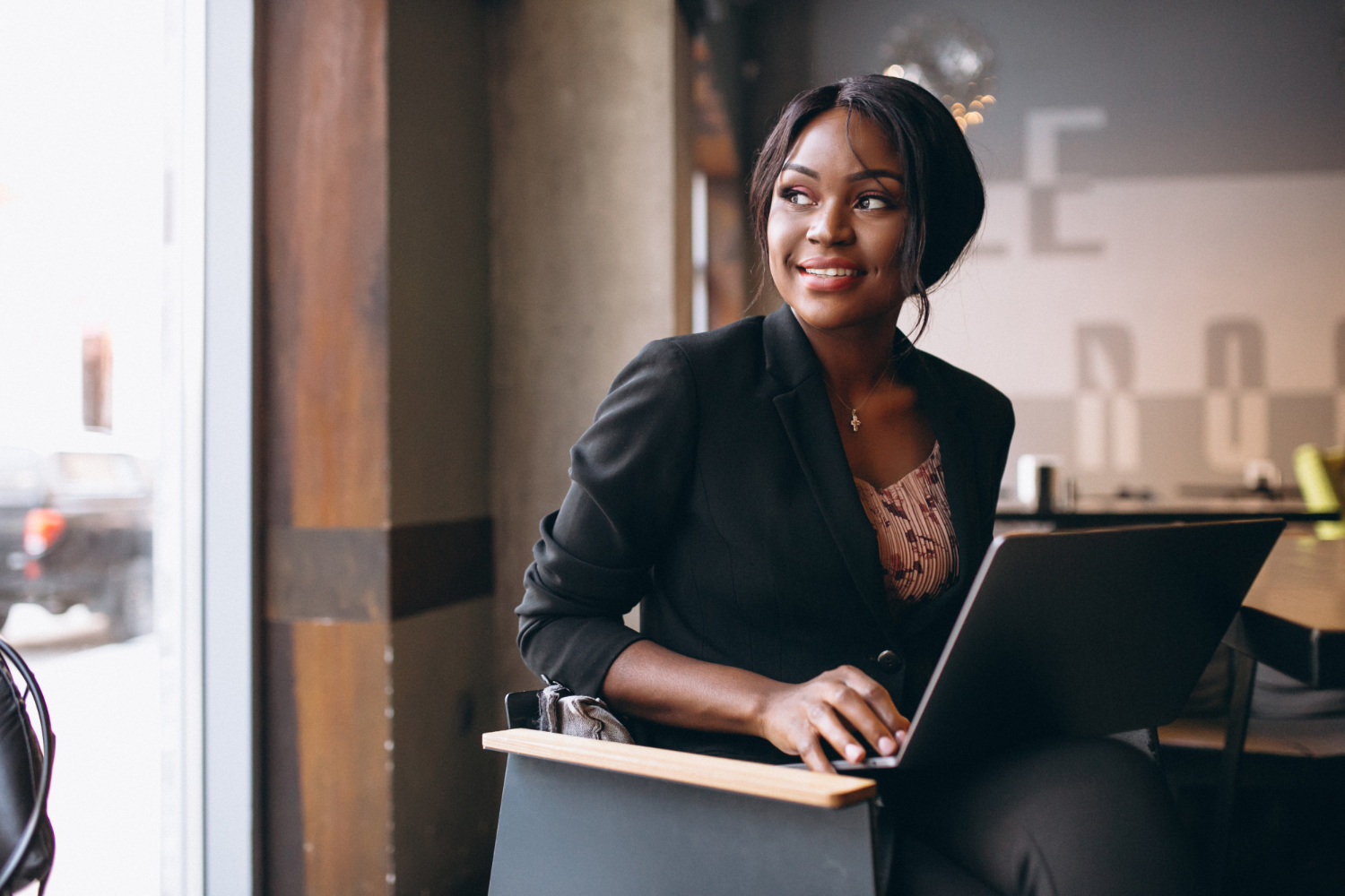 Woman working on her laptop in a bar