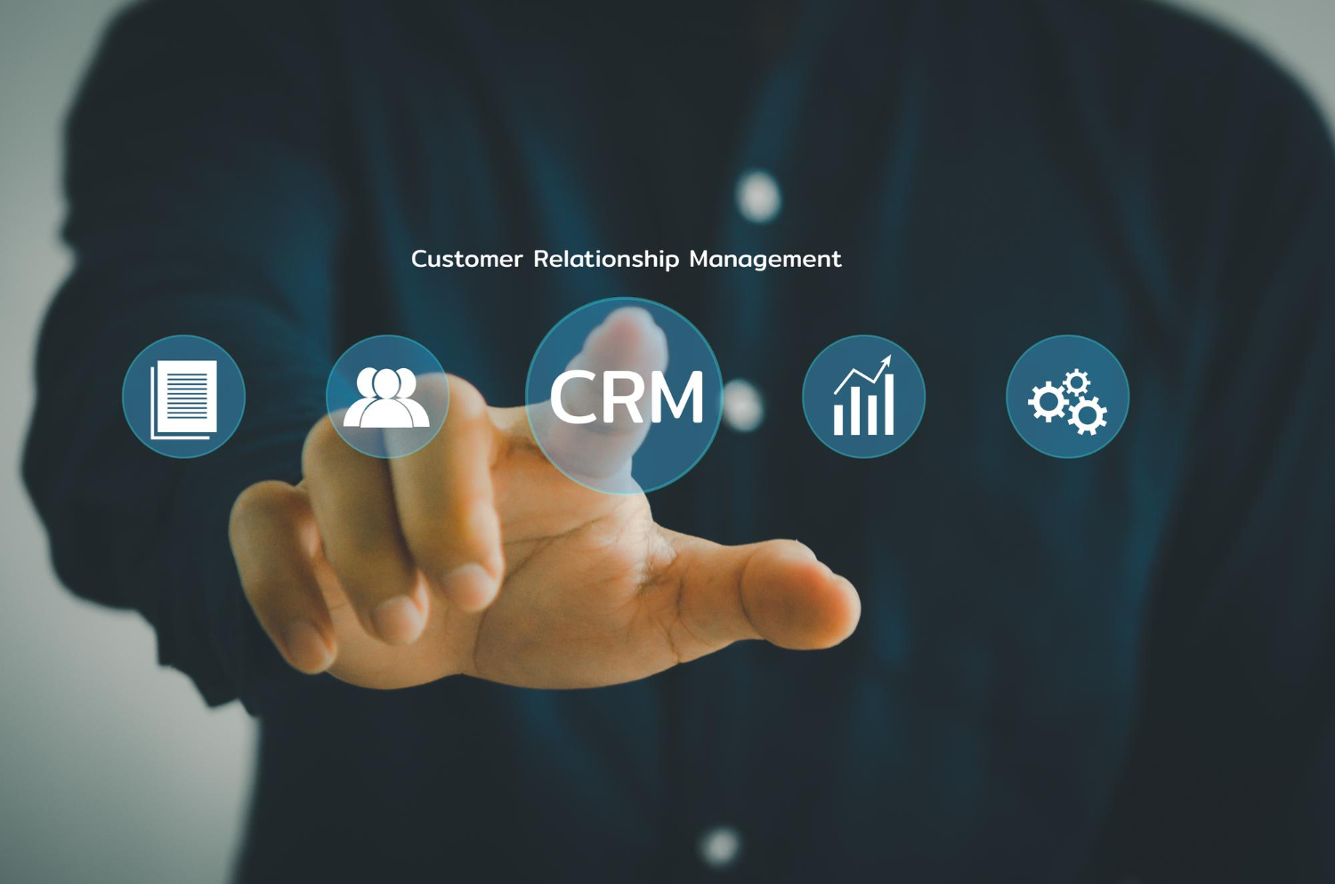 Hand touching a CRM icon on a virtual screen with CRM icons