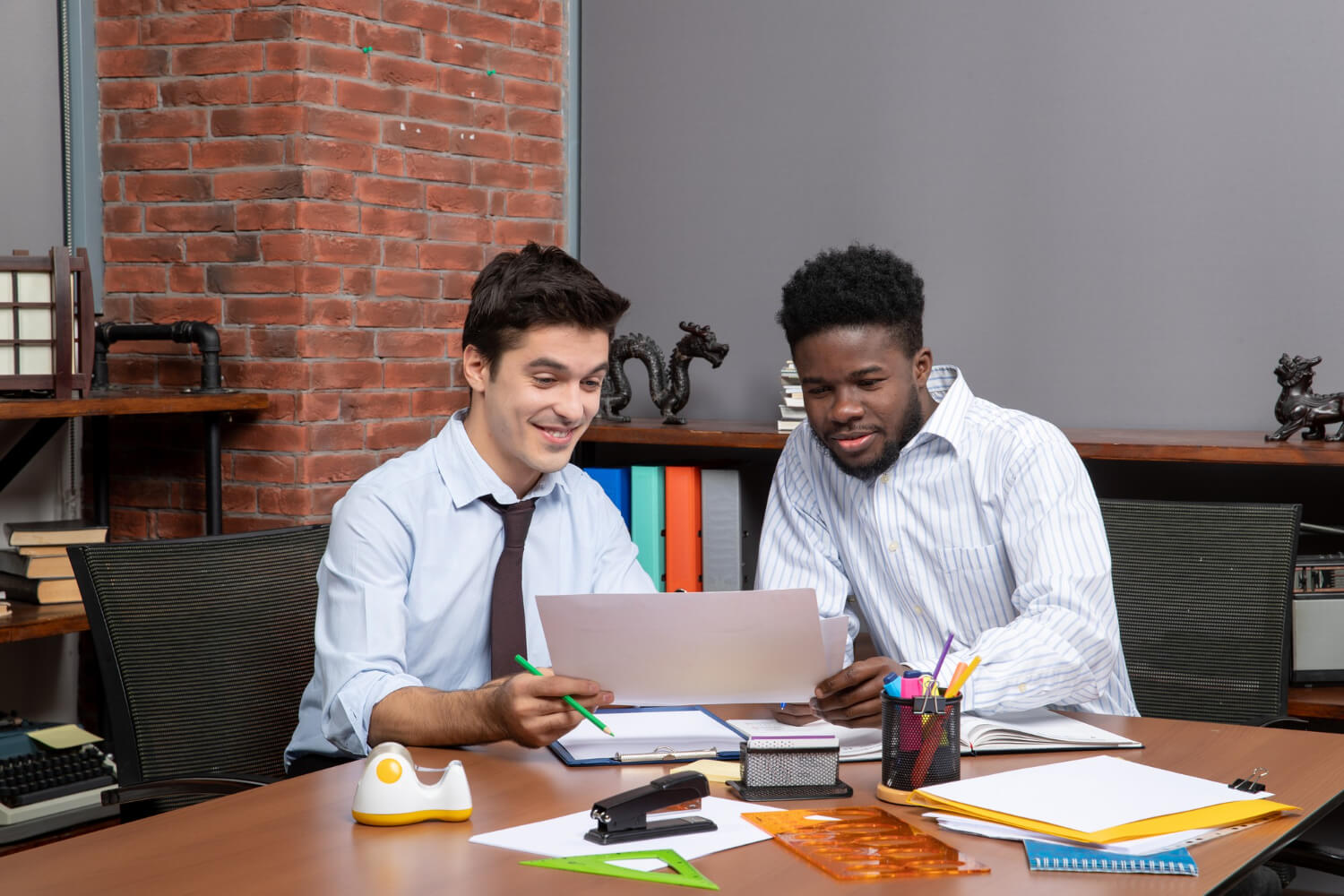 two happy businessmen working together in office